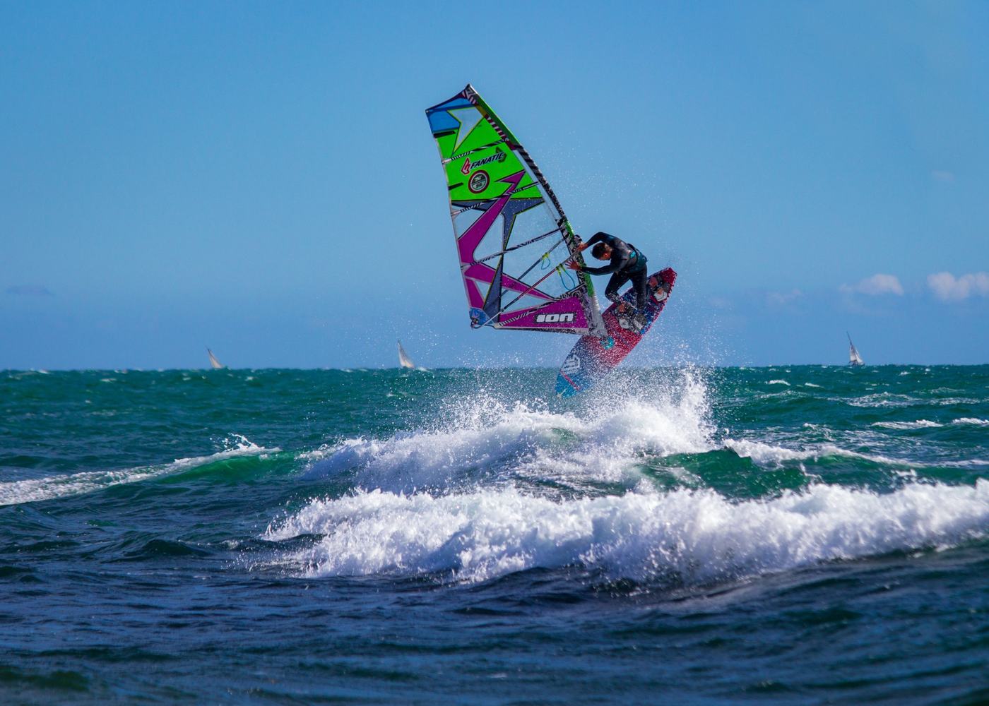 Windsurfer jumping off a wave